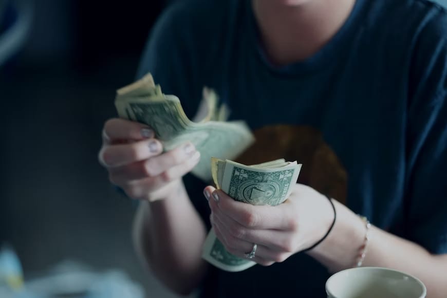 A person counting his dollar notes.