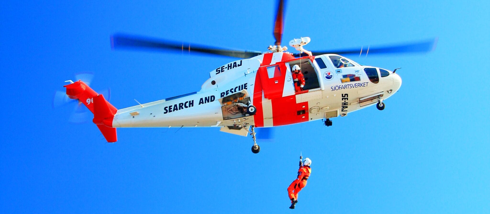 Search and Rescue Officer rappelling down the vessel from a helicopter.