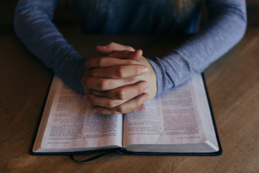 A man praying with the Bible in front of him.