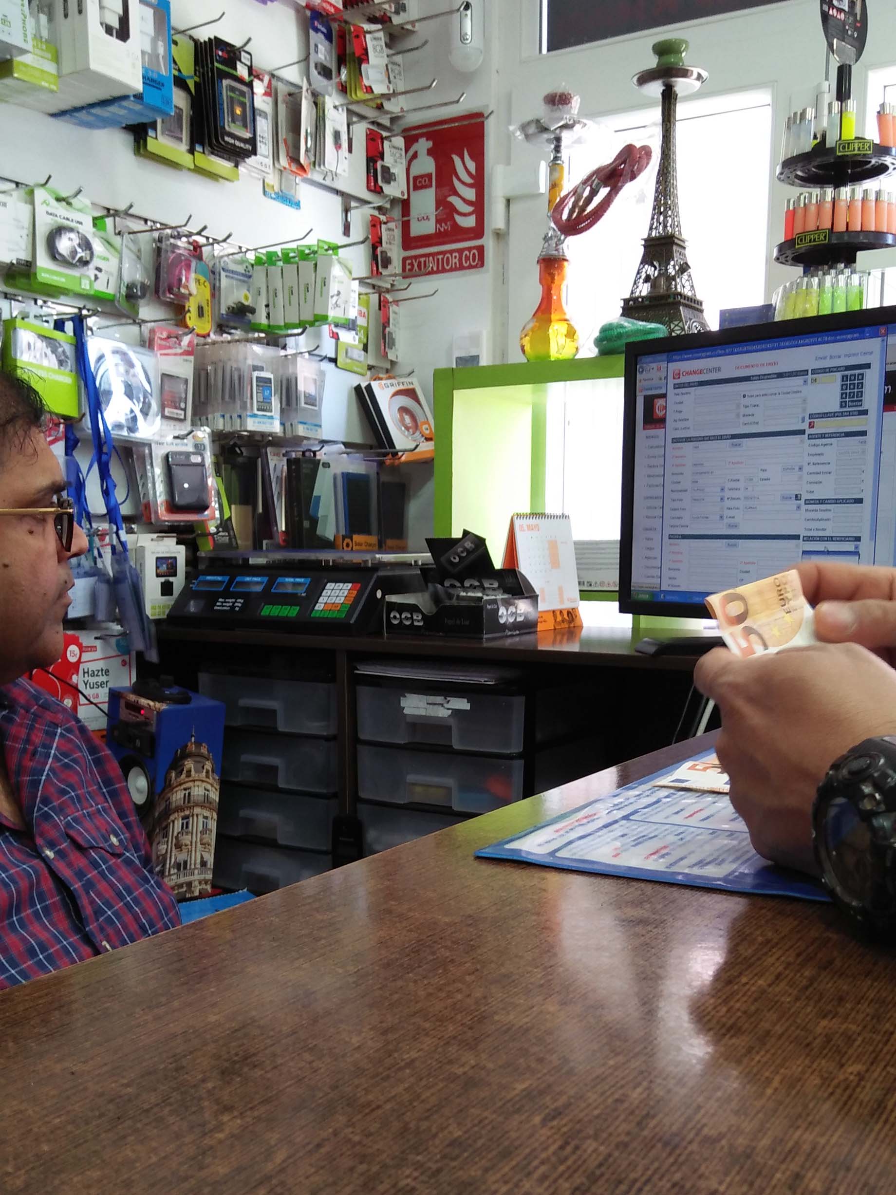A seafarer preparing his cash after filling out a form for sending money to his wife.