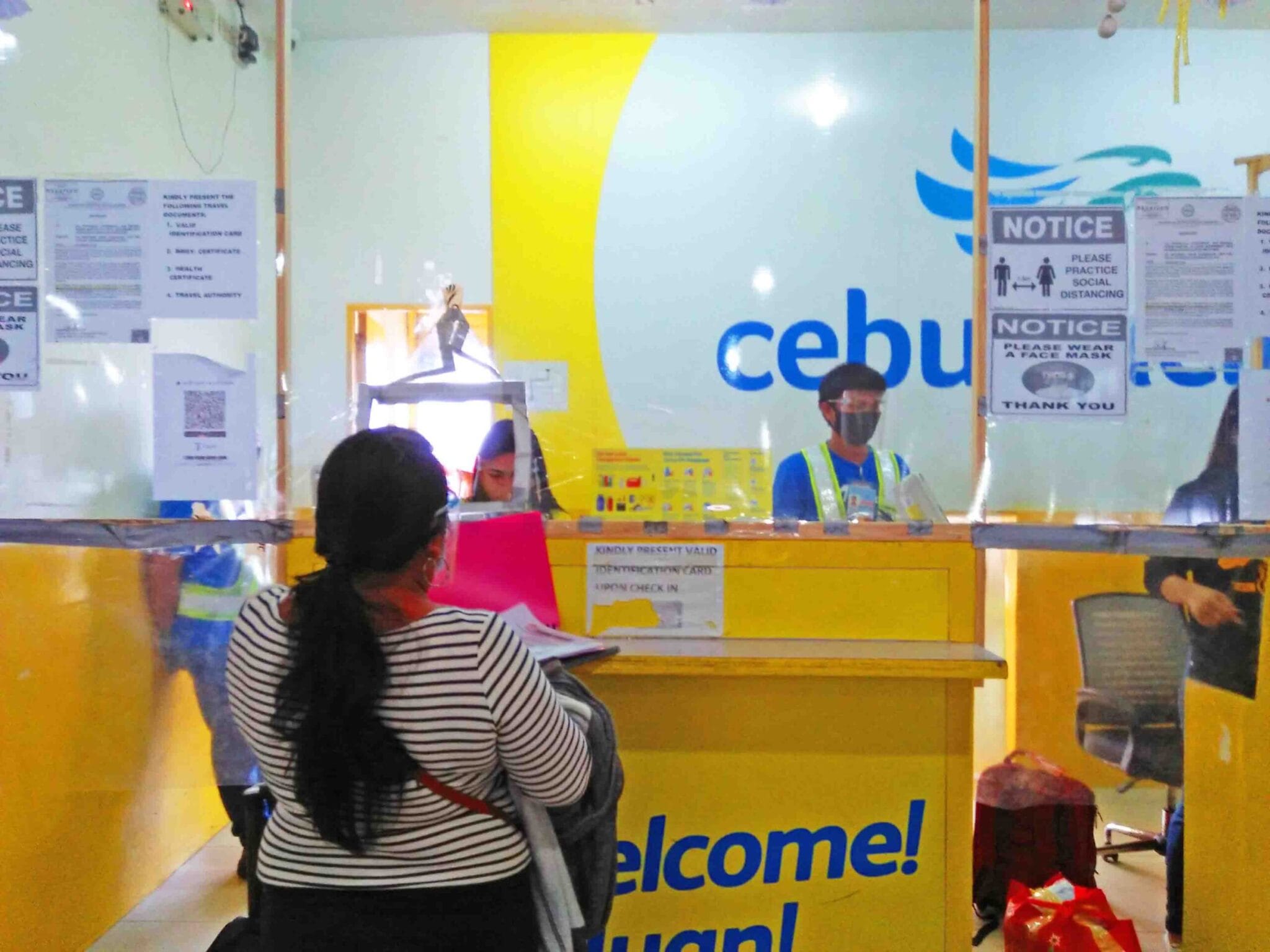 Check in counter at the Cebu Pacific Airline where passengers and crew all wear PPE.