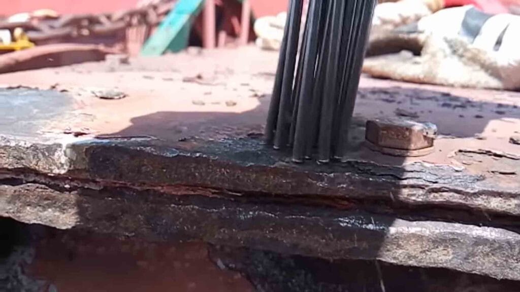 Needle gun scaler chipping away thick corrosion forming on the ship's deck.