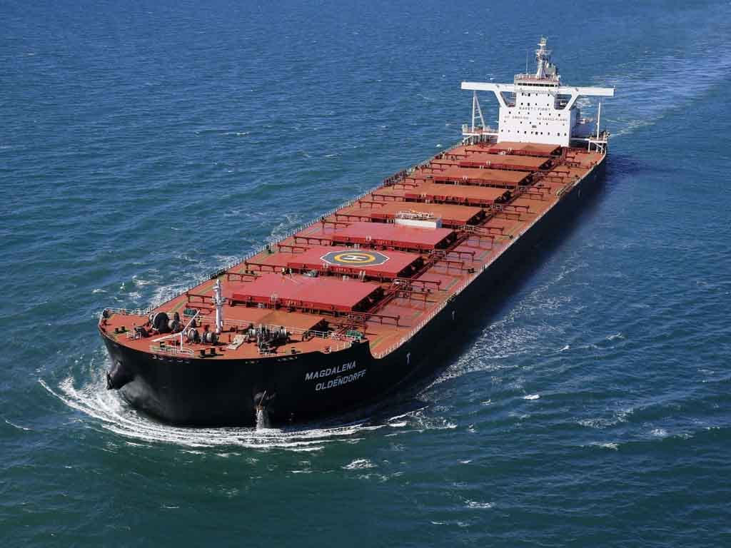 Newcastlemax Magdalena Oldendorff with orange deck and black hull sailing into the sea.
