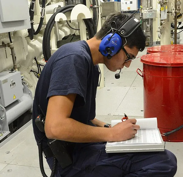 An electrician conducting rounds in the engine room.