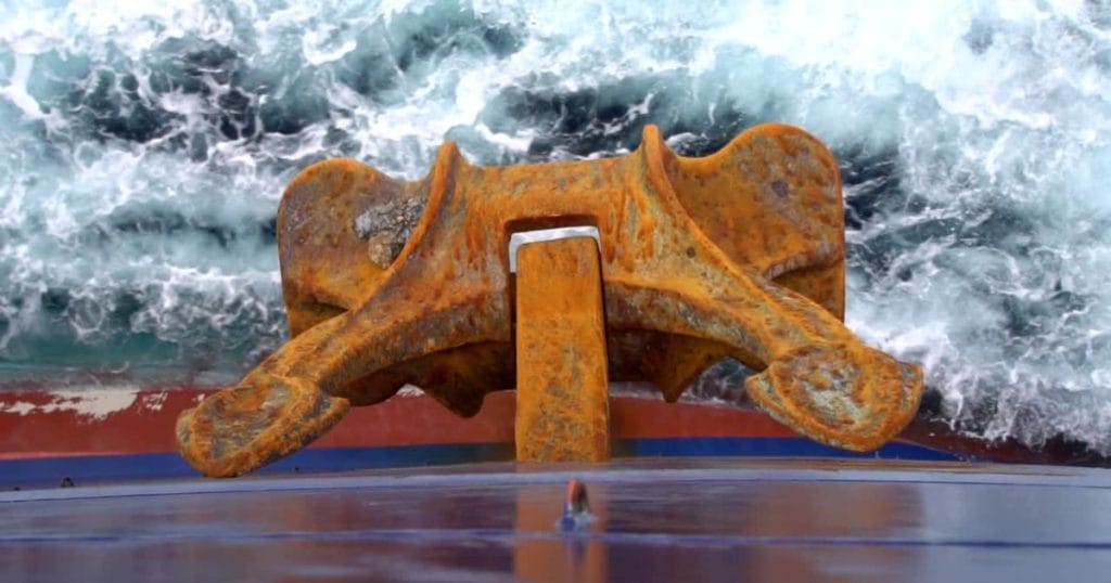 The huge anchor hangs while the ship is moving underway.